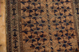 Antique Belouch rug with navy, bronze, and sand serrated leaves and geometric border.