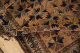 Aged fringe and worn pile on an antique Belouch rug, showcasing navy and sand geometric motifs.