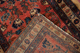 Flipped corner of a Persian Mehreban rug revealing its dense hand-knotted foundation.