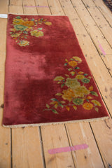 Dusty raspberry red field of a vintage Art Deco runner with patinaed pile and floral corner.