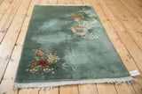Sage green pile with visible wear and tattered fringe on a Chinese Art Deco rug corner.