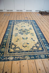Hand knotted vintage Peking rug: cream field, cobalt blue roundel, and Greek key borders.