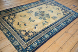Vintage Peking rug corner with blue geometric meander and floral borders.