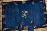 Cobalt blue Peking rug field with a central floral blossom and beige border roundels.