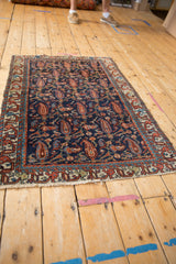 Vintage Mehreban rug lower corner with red, blue geometric border and worn fringe.