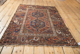 Corner of vintage Kamseh rug, wide terracotta border with navy cypress tree motifs.