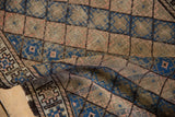 Textural fold of vintage Belouch rug, with alternating rows of beige, blush, and blue diamond patterns.