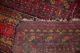 Hand-knotted foundation and tattered edges of the vintage Afghan rug.