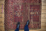 Worn fringe, serrated leaf border, and ram's horn motifs of an antique Turkmen rug.