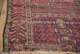 Antique Turkmen's burgundy and navy geometric patterns, ivory serrated leaf border, visible wear.