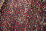Worn antique Turkmen rug close-up: burgundy, navy multi-paneled design, exposed foundation.