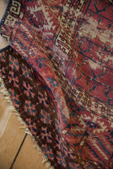 Worn pile texture of antique Turkmen rug, showing ram's horn border, fringe, burgundy, and navy.