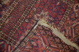 Worn detail of antique Turkmen rug, burgundy and navy serrated leaf border, revealing woven foundation.