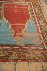 Worn texture on the stepped prayer niche of a red and sky blue vintage Anatolian rug.
