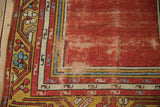 Visible foundation and hand-knotted texture on a vintage Anatolian rug's worn cherry red corner.