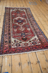 Vintage Hamadan runner detail showing arrowed medallion, Herati design, and tattered navy border.