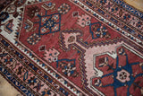 Vintage Hamadan runner with geometric motifs, zig-zag borders in brick red, navy, and blush.