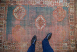 Worn pile of an antique Oushak rug revealing turquoise, coral, and ivory medallions.