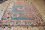 Antique Angora Oushak rug with tattered fringe and worn pomegranate blossom border.