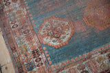 Worn pomegranate blossom border of antique Angora Oushak rug with turquoise and faded tones.