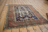 Visible foundation and knot wear on the navy field of the vintage Karaja rug.