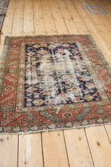 Geometric blossoms and foundation wear on a vintage Karaja rug with terracotta and navy.