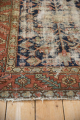 Vintage Karaja rug end with wear, terracotta, navy, and pale green geometric borders.