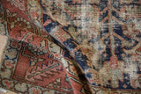 Vintage Karaja rug close-up: worn pile revealing foundation, navy blue, and terracotta tones.