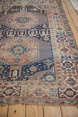 Detail of antique Shirvan rug's Kufic style border with geometric patterns and worn end fringe.