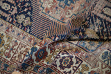 Antique Shirvan rug's Kufic border and geometric field patterns in navy, terracotta, and beige.