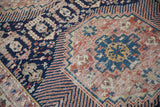 Stepped geometric motifs, Kufic-style elements, and time-softened texture on an antique Shirvan rug.