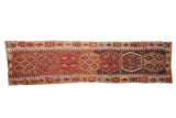 Turkish Kilim runner featuring hexagonal medallions, geometric florals in charcoal, raspberry, tangerine.