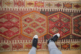 Vintage Turkish Kilim runner showcasing geometric hexagonal medallions in red, tan, and charcoal.