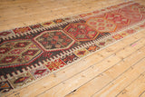 Vintage Turkish Kilim runner features charcoal, red, and tan oversized hexagonal medallions.