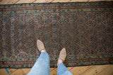 Antique Kurdish Hamadan runner's shadow boteh pattern, aubergine ground, blues, reds, and pile wear.