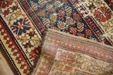 Detailed view of the vintage Caucasian runner's striped foundation and dark outer edge.