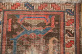Hamadan rug corner with distinct red, sky blue, charcoal dragon motif, showing wear.