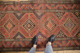 Vintage Kurdish Hamadan runner, repeating cochineal red diamond medallions with stylized hook guls.
