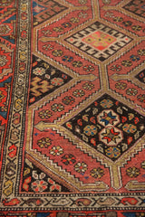 Kurdish Hamadan runner's repeating diamond medallions and snowflake guls in dusty red and brown.