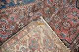 Vintage Malayer rug's faded red and blue front, tattered edge, and brighter reverse.