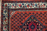 Corner detail of a Persian Engelas rug showing the blossom and wave motif borders.