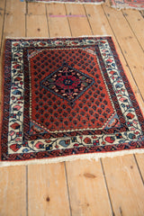 Angled view of a vintage Persian Engelas rug, detailing the central medallion and floral border.