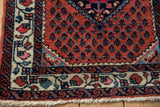 Hand-knotted corner of a Persian Engelas rug showing its boteh field and floral borders.