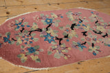 Detail of vintage Nichols rug showing jet black dragon-like branches and pastel lotus flowers.