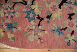 Close-up of vintage Art Deco rug with jet black dragon-like branches and multi-colored blossoms.