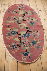 Nichols Art Deco rug showing dusty rose ground, black branches, colorful blossoms, and tattered edge.