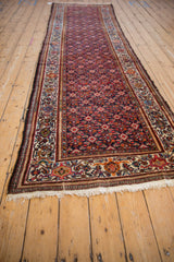 Long perspective of a vintage Malayer runner showing its intricate navy and red Herati pattern.