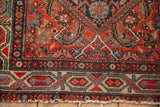 Border detail of vintage Hamadan rug with red, blue, green patterns and tattered fringe.