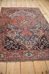 Persian traditional Farahan Sarouk rug detail with shield medallion, floral vinery, coral, navy, teal colors.