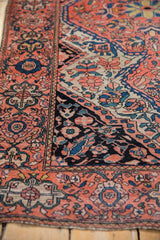 Farahan Sarouk rug's intricate coral, navy blue, and black floral patterns, with even wear.